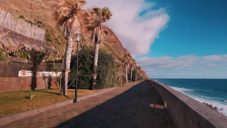 Pov-Tiro-Delantero-A-Lo-Largo-Del-Paseo-Marítimo-Durante-La-Puesta-De-Sol-En-Jardim-Do-Mar,-Portugal