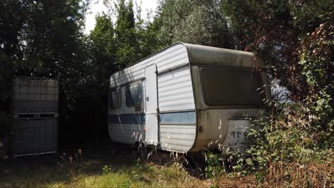 in the corner of a forest a two berth caravan is utilised for storage