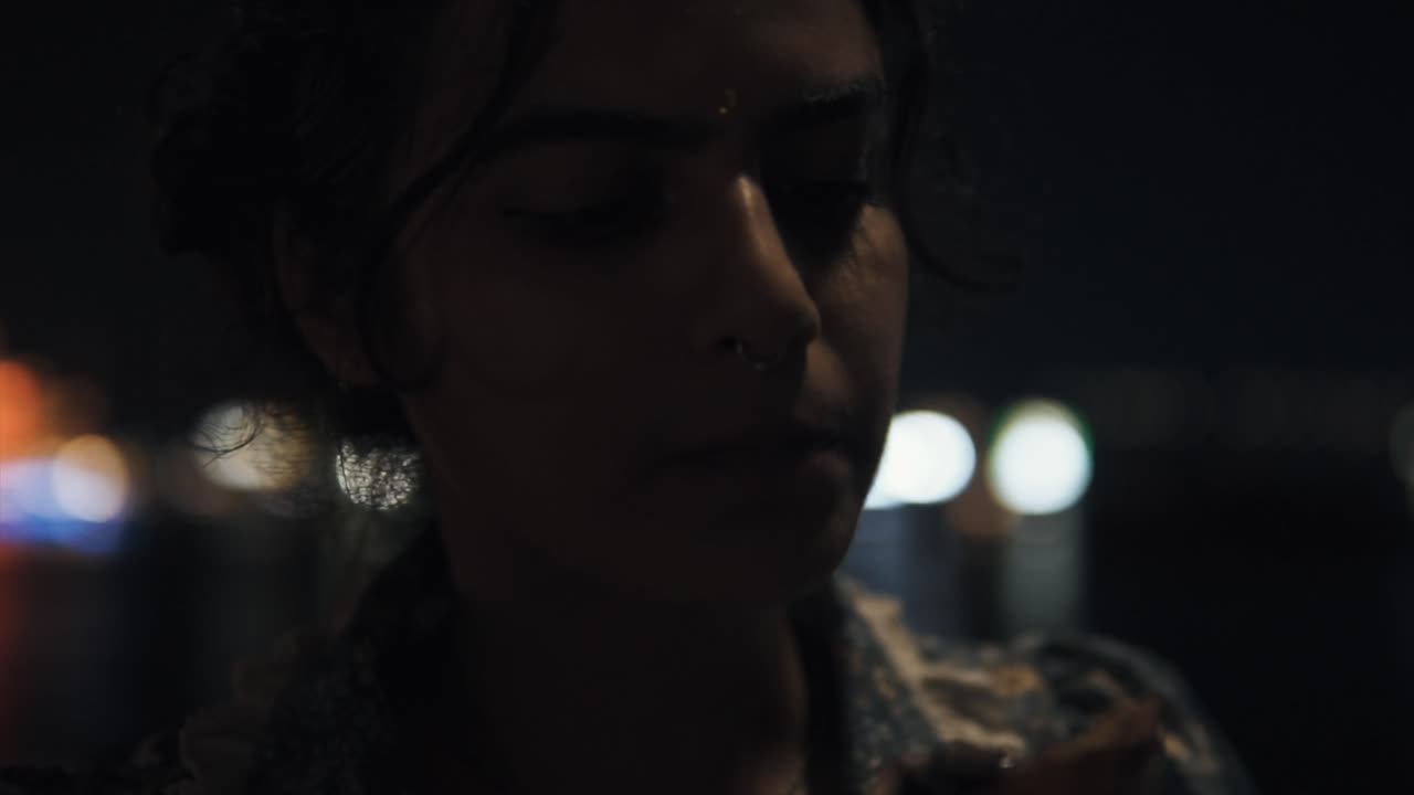 ⁇ 린 코를 가진 아름다운 젊은 인도 여성이 여름 밤에 아이스크림 코너를 먹고 있습니다.