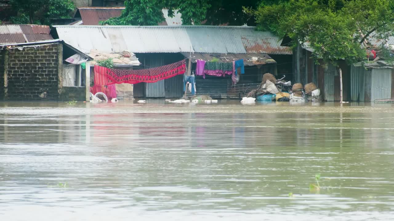 Flood crisis. Tin shed slum house affected by overflowing river water. Bangladesh, South Asia