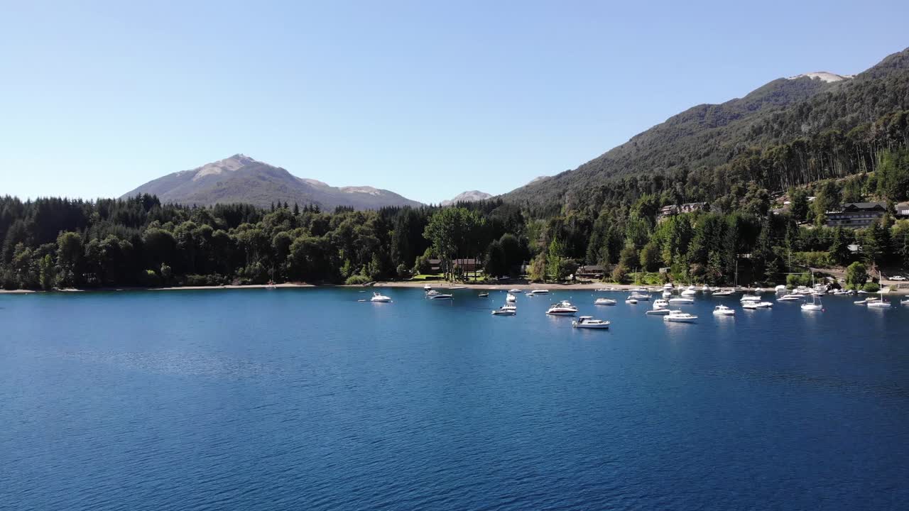 la antena de superficie baja del lago se eleva para volar sobre los barcos amarrados en la bahía tranquila