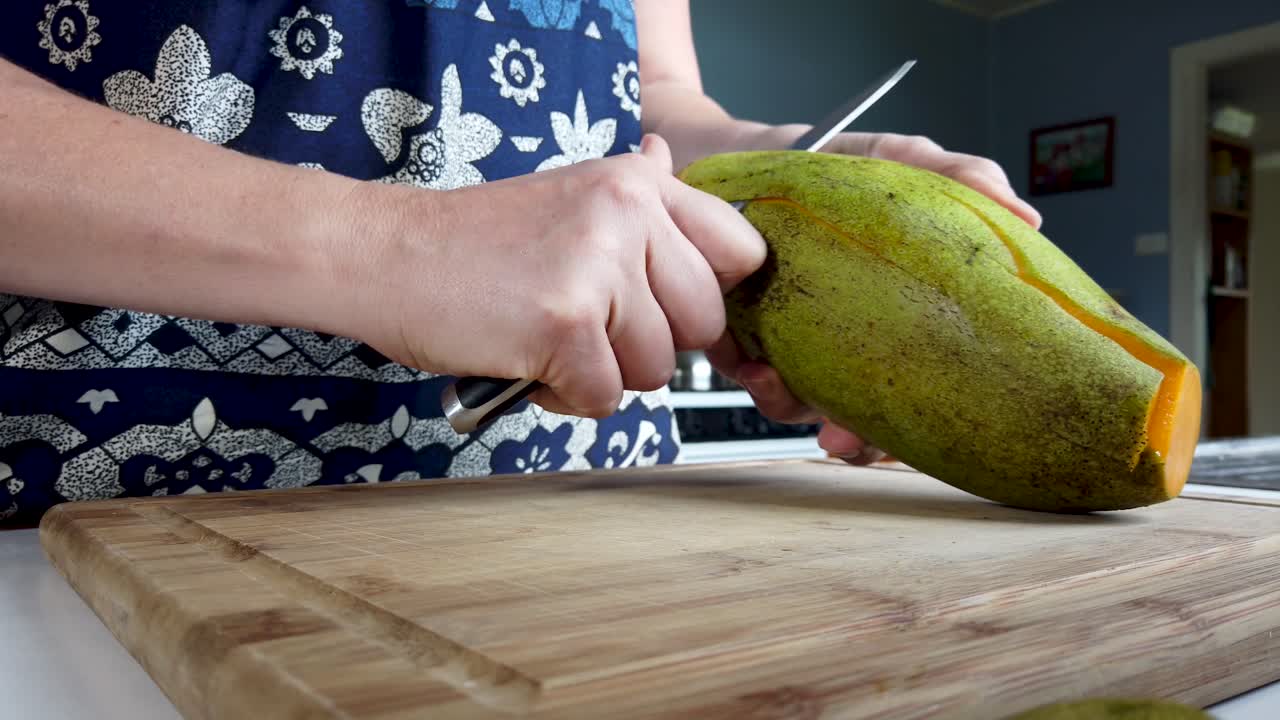 primer plano pelando fruta de mango maduro con cuchillo de cocina, preparación de alimentos