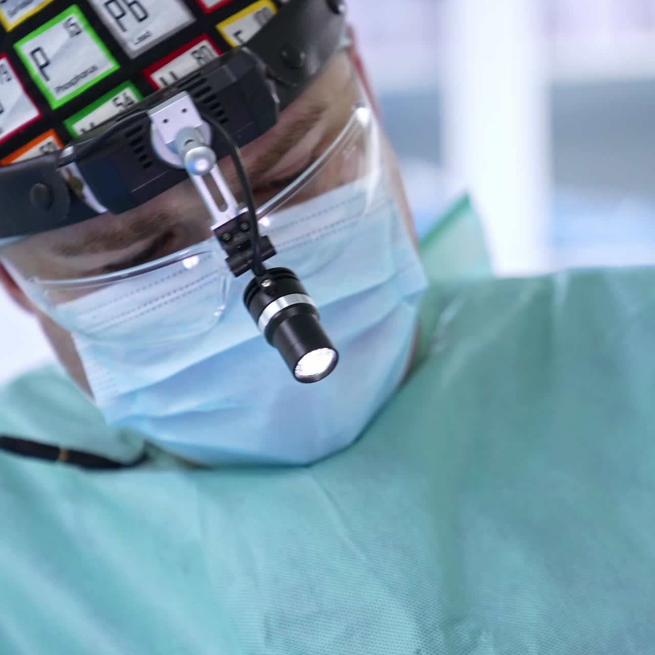 Equipped surgeon conducting the operation. Doctor cutting the thread with scissors close up. Blurred backdrop