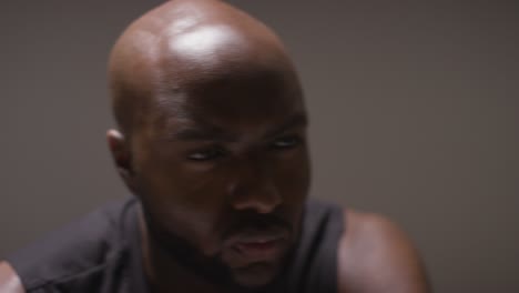 close up studio shot of seated male basketball player with hands holding ball 2