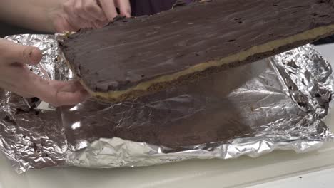 a young korean girl removes the finished millionaire shortbread cookie and places it onto a cutting board