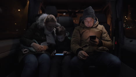 passengers in minibus passing the time with cellphones