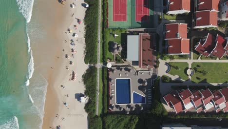 La-Vista-Aérea-A-Vista-De-Pájaro-Captura-La-Playa-Brava-Y-Un-Complejo-De-Condominios-De-Lujo-Que-Cuenta-Con-Una-Piscina-Y-Diversas-Comodidades.