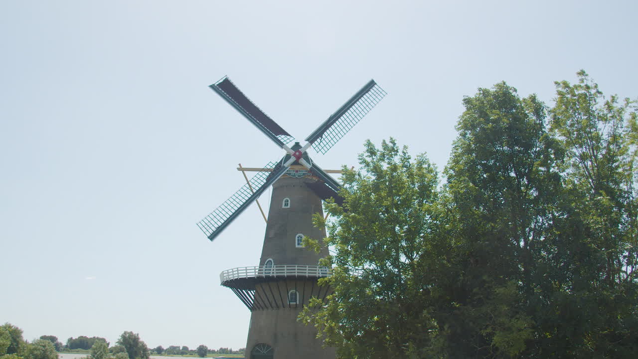 красивая старая голландская ветряная мельница с вращающимися на ветру лопастями