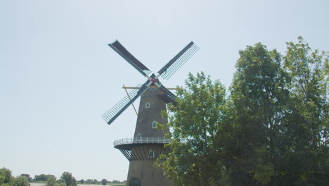 hermoso y antiguo molino de viento holandés con aspas girando en el viento