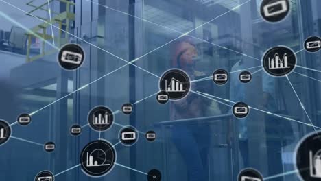 Animation-of-network-of-digital-icons-against-diverse-man-and-woman-discussing-in-elevator-at-office