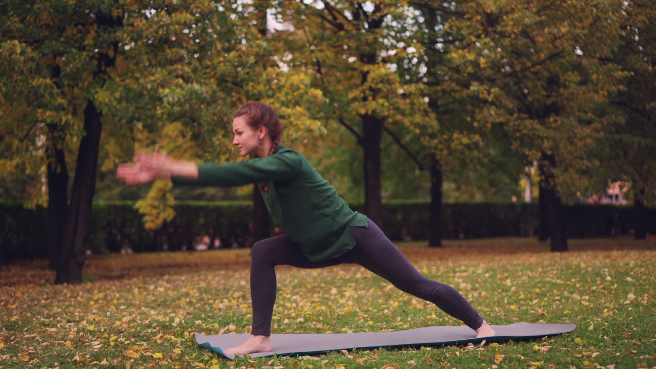 Woman practicing yoga in a park during autumn