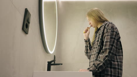 person brushing teeth in modern bathroom