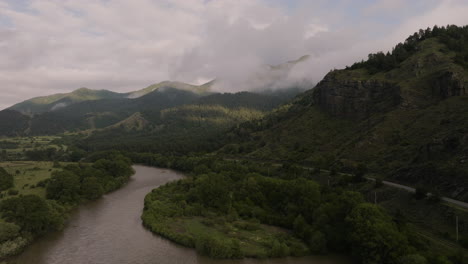 Aerial-View-Of-Mountain-Pass-Along-The-River-On-Overcast-Day-In-Georgia