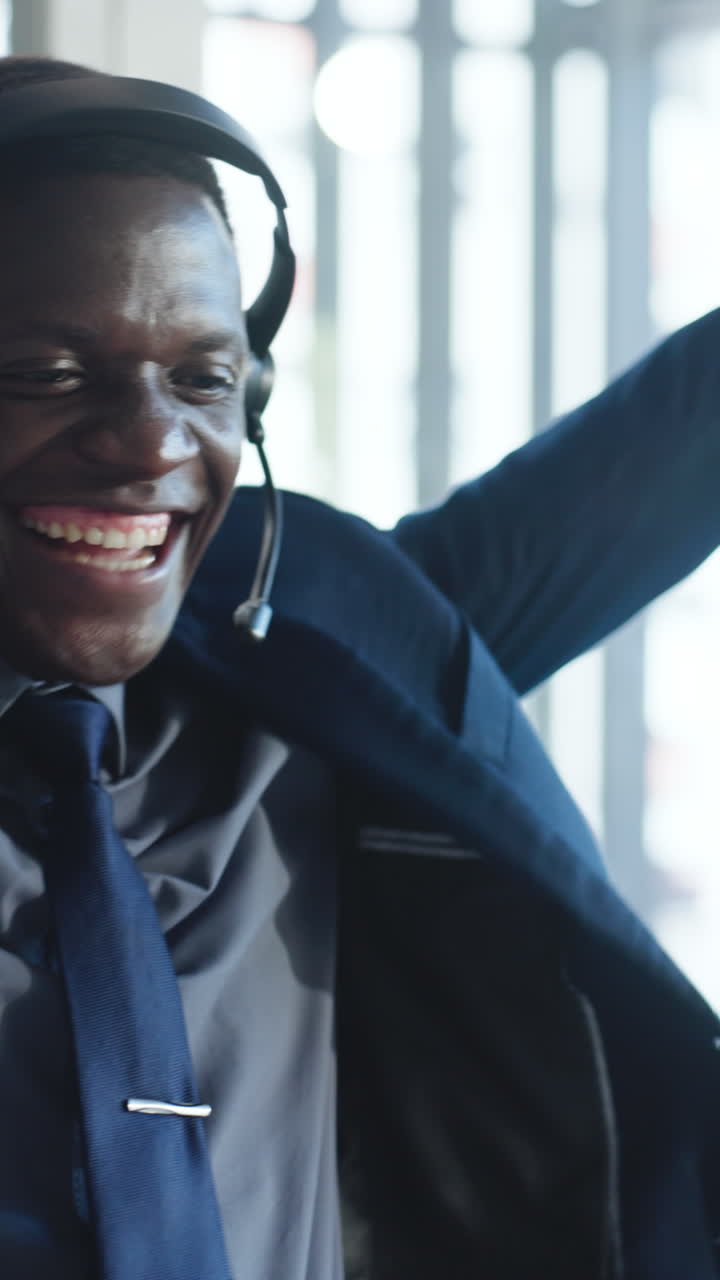 Happy Young Man in Headset Celebrating Success While Working on Laptop