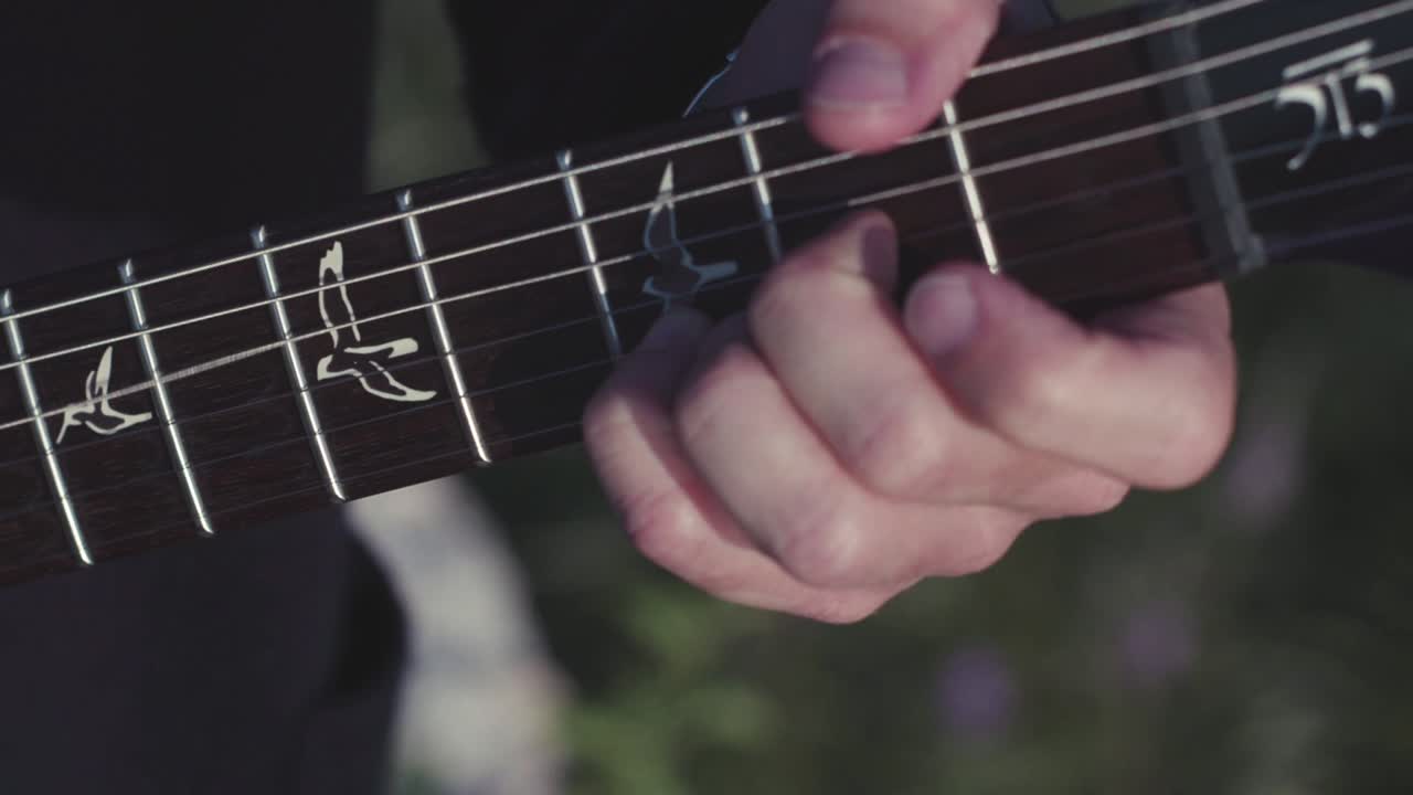 Closeup of hands playing an electric guitar