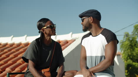 gay man sitting on roof and explaining his point of view to partner