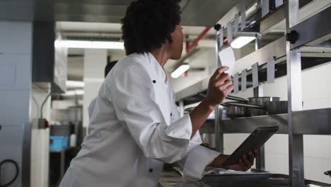 chef afroamericana tomando pedidos en la cocina del restaurante