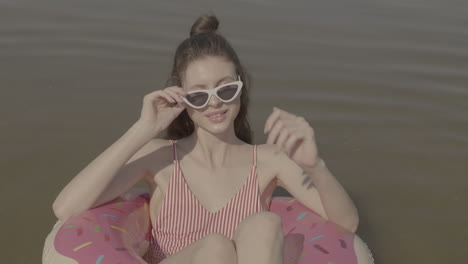 woman relaxing on donut float in water