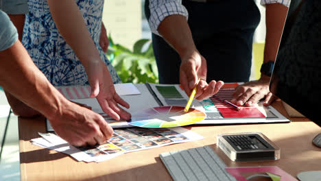 Team-of-graphic-designers-discussing-over-color-swatches-in-office-4k