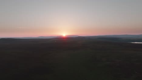 puesta de sol sobre el expansivo páramo en un día de verano nebuloso, avión no tripulado