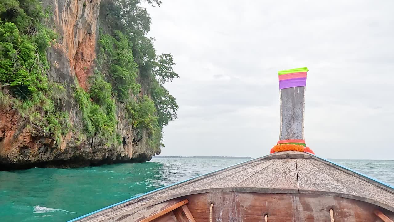 Boat travels near island cliffs in Krabi, Thailand
