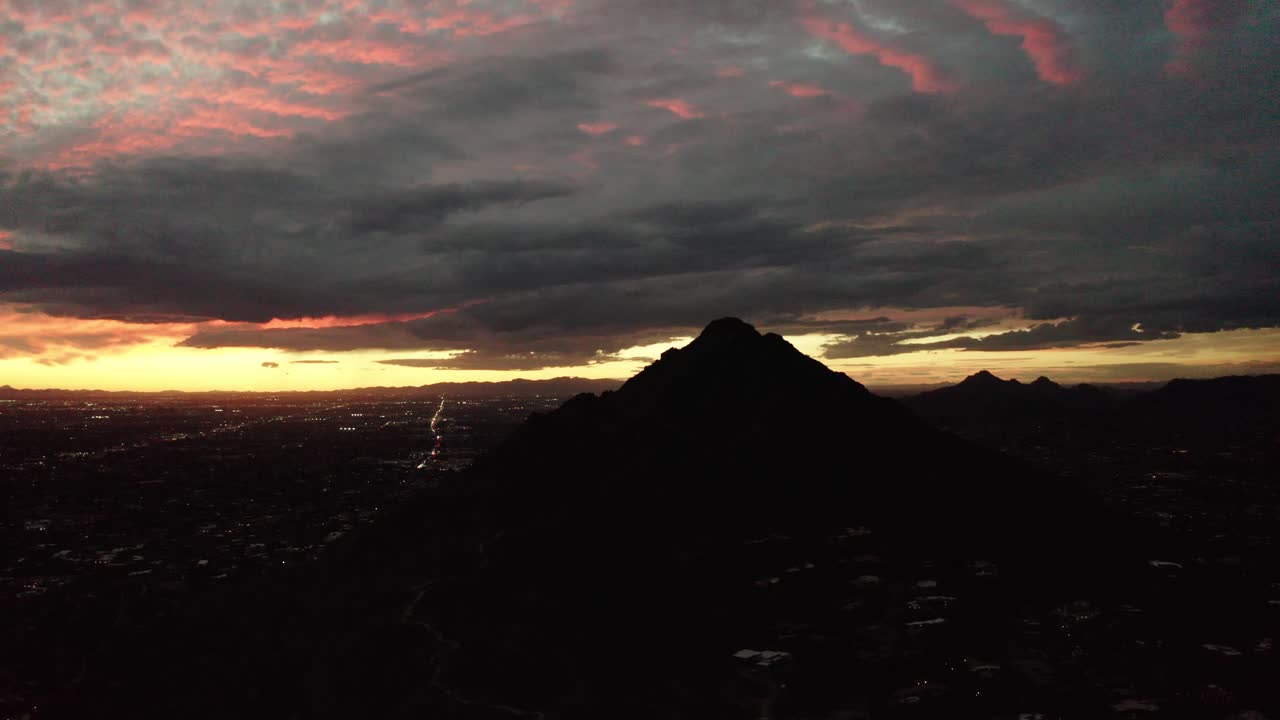 Wide aerial view of Camelback Mountain in Arizona surrounded by the setting sun