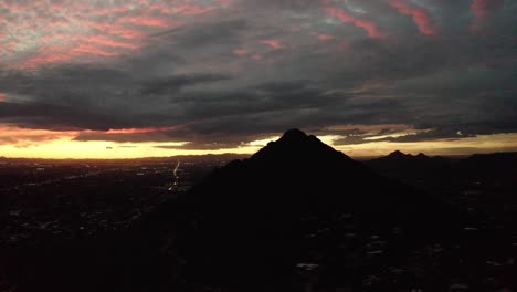 wide aerial view of camelback mountain in arizona surrounded by the setting sun