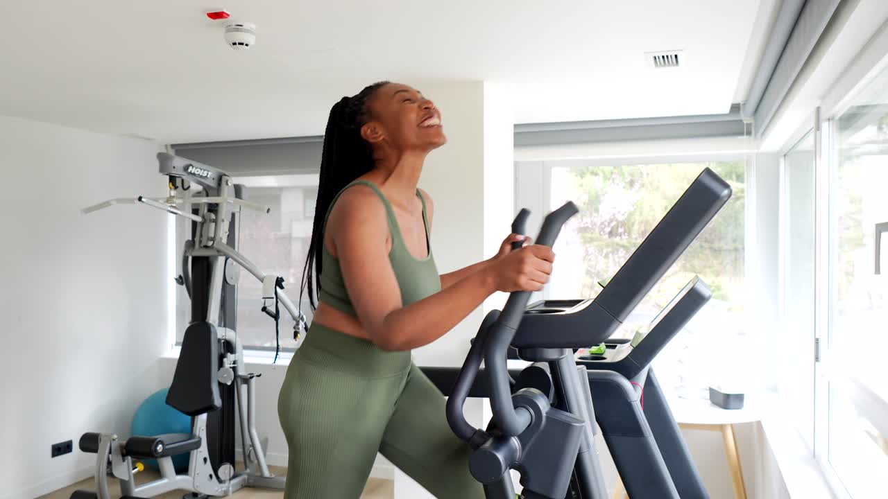 Woman exercising on elliptical machine in gym