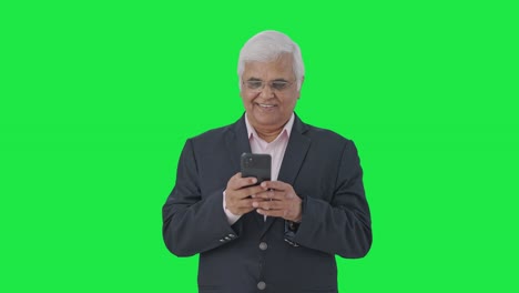 Happy-Indian-senior-manager-using-mobile-phone-Green-screen