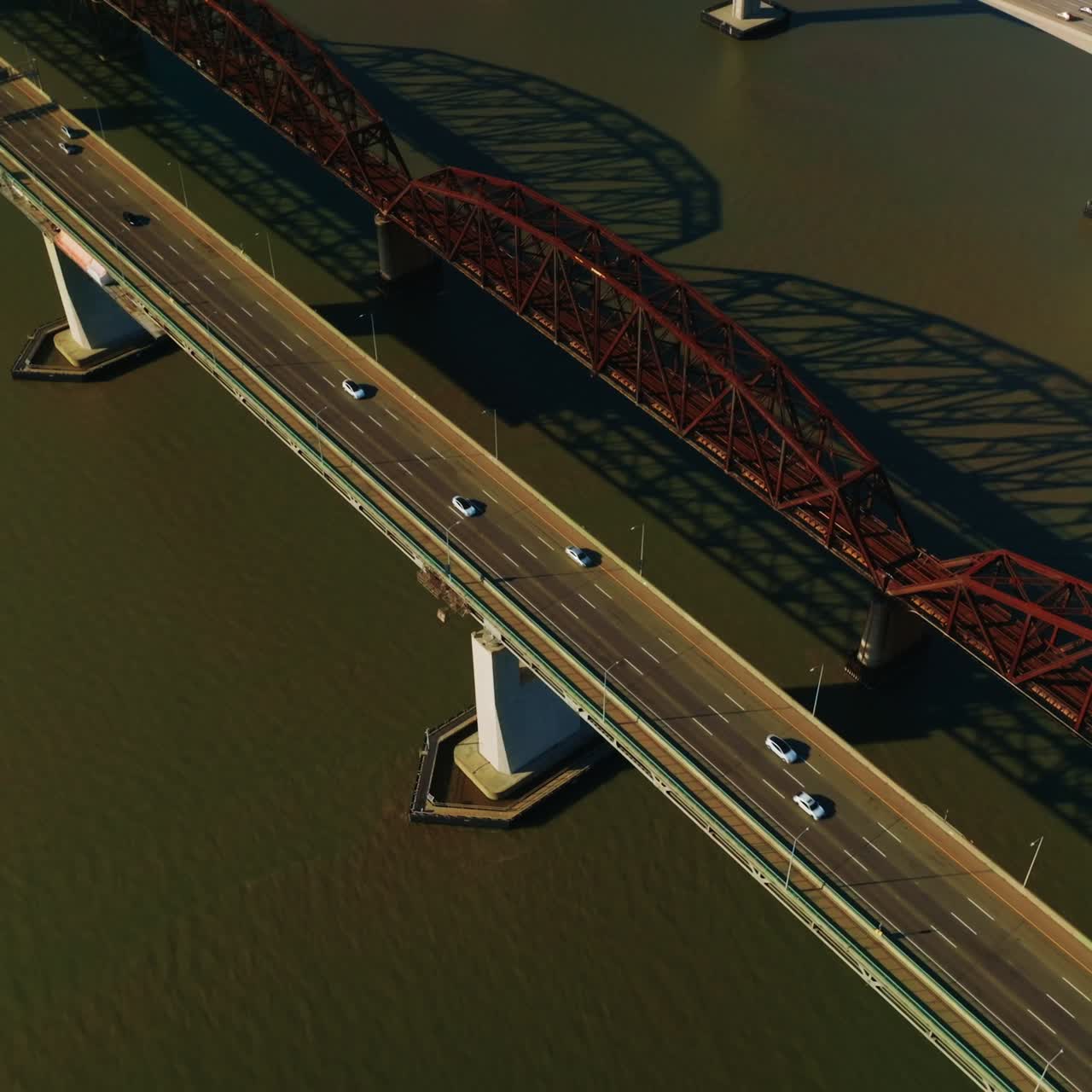 Automobile and railway bridges over California bay, USA. Three Martinez bridges over the dark water on sunny day. Top view