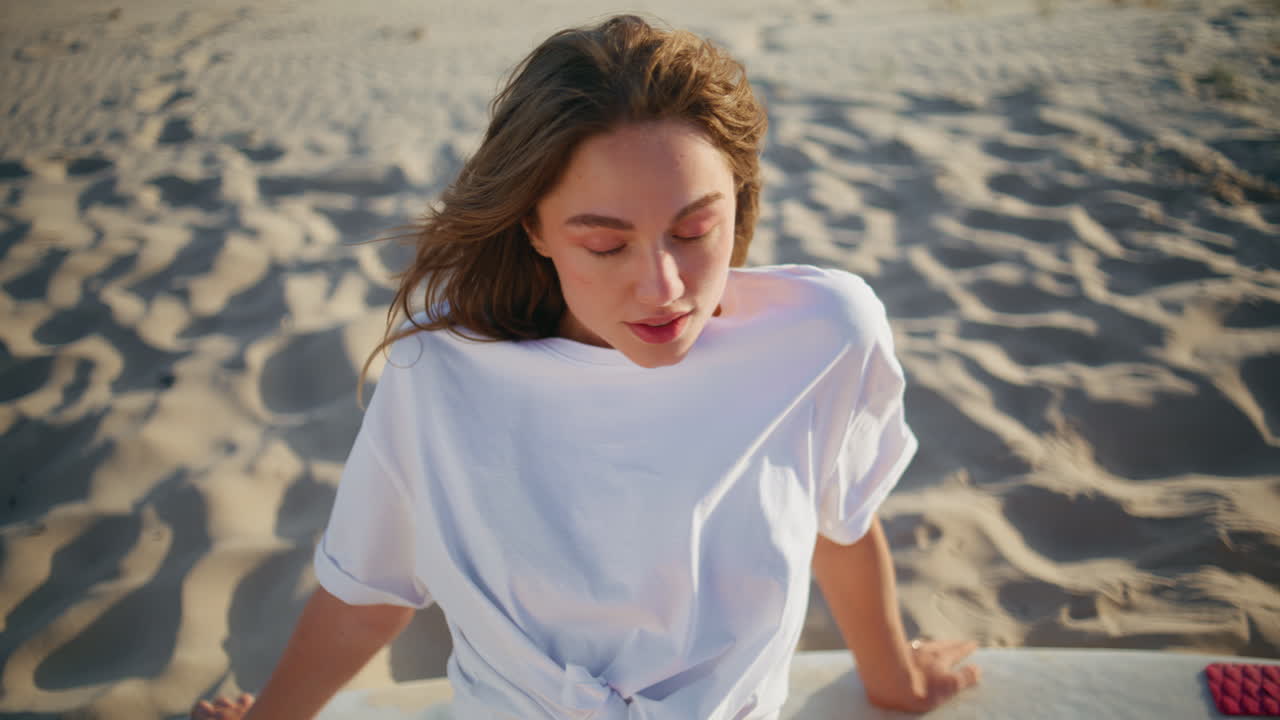 Sexy lady basking sun sitting at sandy shore closeup. Windy hair woman relaxing