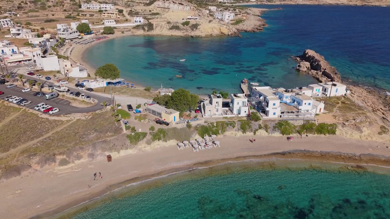Riprese con drone che catturano la spiaggia di Lefkos a Karpathos, rivelando acque turchesi cristalline prima di svelare una seconda splendida spiaggia con acque altrettanto vivaci oltre