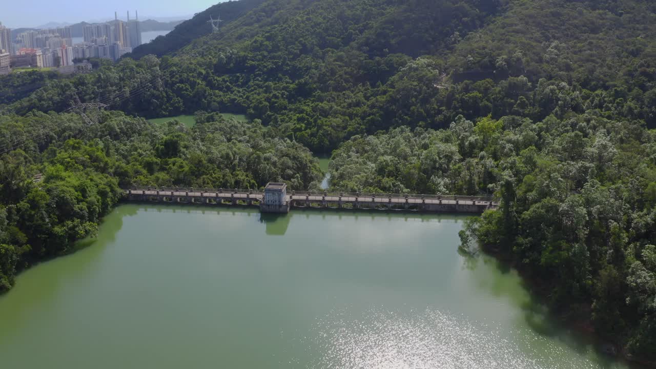 낮 동안 숲에서 댐 위를 날아다니는 시네마틱 드론 샷