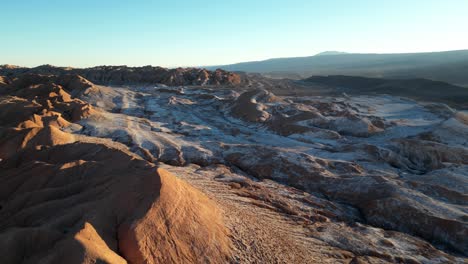 Sunset over Valle de la Luna in the Atacama Desert, with dramatic desert formations bathed in warm light