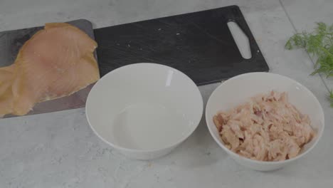 primer plano en cámara lenta de un chef cortando un poco de pescado y luego colocándolo en un bol