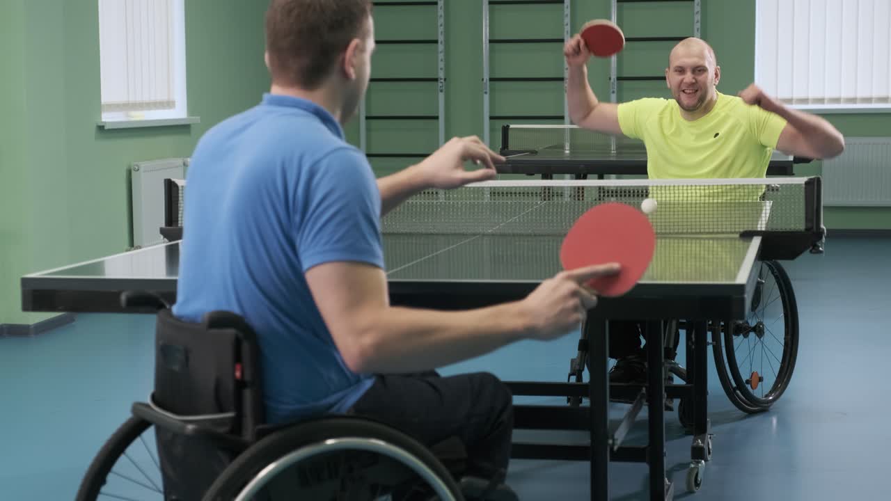 hombres discapacitados jugando al tenis de mesa
