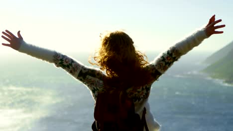 woman standing with arms outstretched near a sea 4k