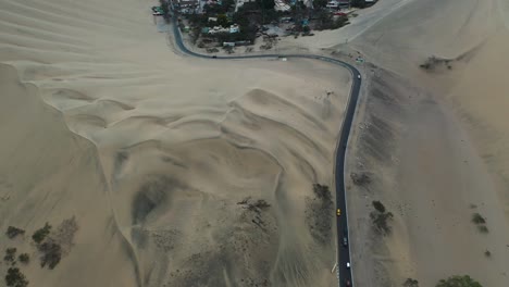 aerial flight above peru's huacachina desert oasis village in the desert