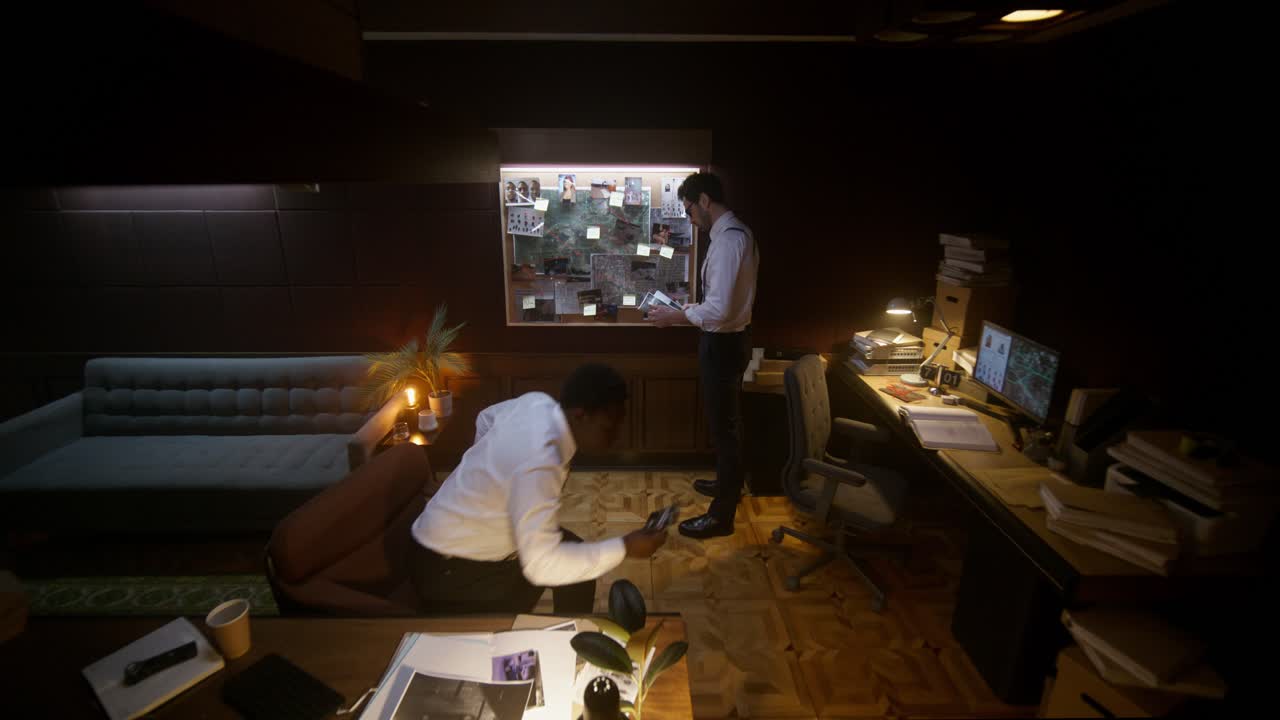 Detectives Discussing Evidence in a Dimly Lit Office