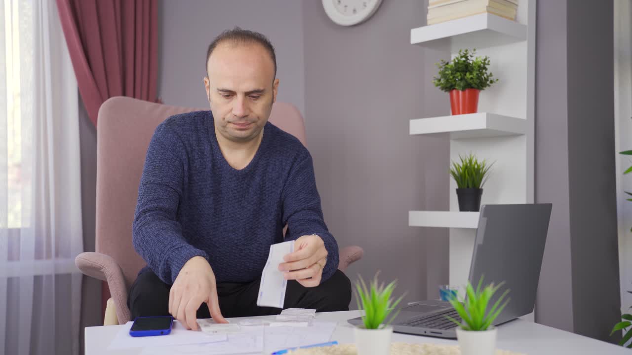 el hombre que hace cálculos financieros en la economía doméstica está endeudado y desesperado.