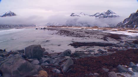 a beautiful foggy snow covered shoreline amidst fjords north of the arctic circle in lofoten islands norway 1