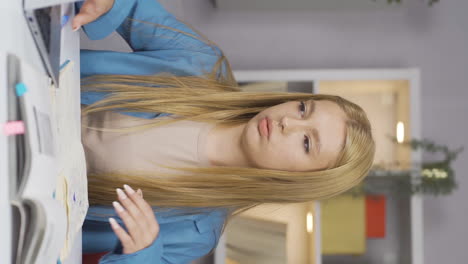 vertical video of unhappy female student arriving at his desk.