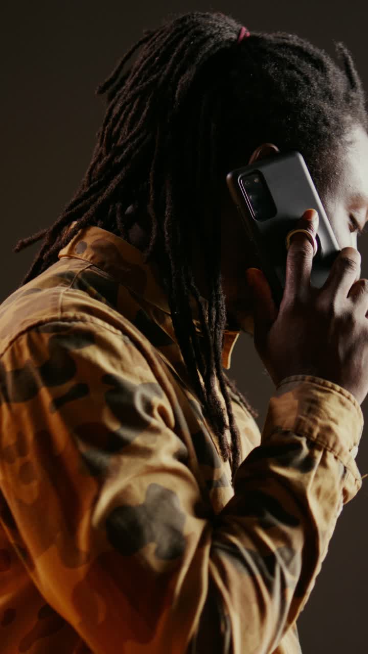 Video verticale Un tipo cool con i dreadlock risponde a una telefonata in studio