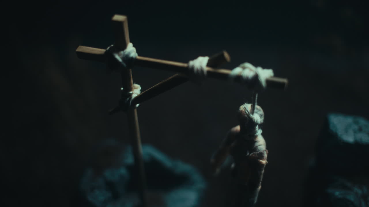 Miniature mummified dolls hanging on the gallows at night