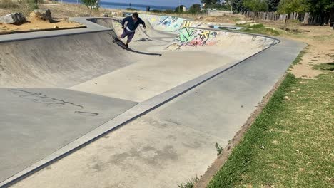 happy young man skateboarding at skate park in the city