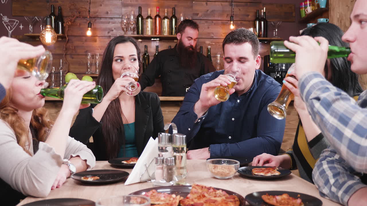 Friends Enjoying Beer and Pizza at a Bar
