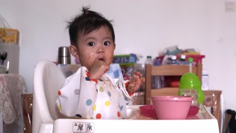 Linda-Niña-Asiática-De-Un-Año-Comiendo-Y-Lamiendo-Una-Cuchara-Después-De-Comer-Mee-Frito