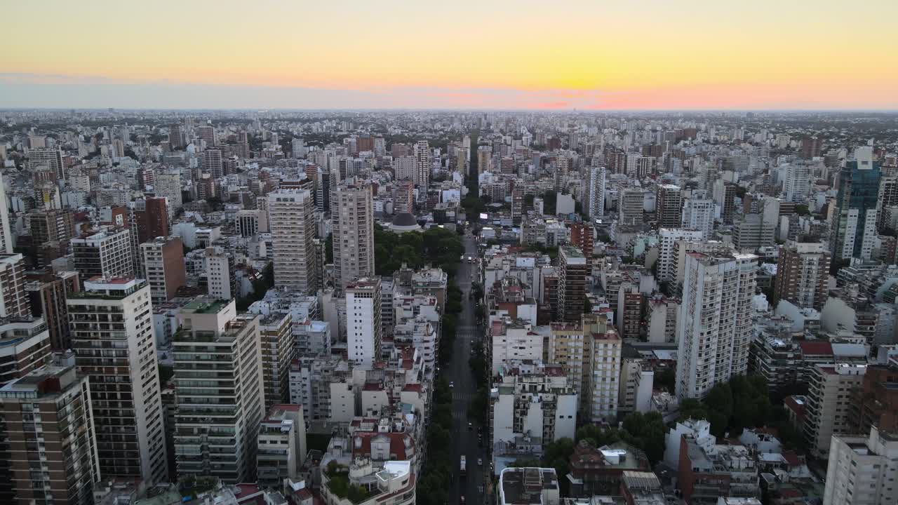 dolly volando sobre la avenida larga al atardecer en medio del concurrido barrio de belgrano, buenos aires, argentina