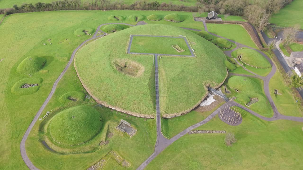 Knowth prehistoric site with grass-covered tombs and ancient passageways, aerial view