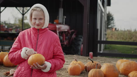 Portrait-of-a-farm-girl-with-a-pumpkin.-Fall-holidays-and-Halloween-in-the-USA